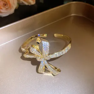 Detailed shot of a gold-finish bow bracelet with sparkling pavé zircon stones