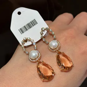 Detailed macro shot of vintage gold-plated champagne pear-shaped crystal and pearl earrings