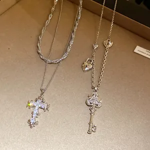 Close-up of vintage silver zircon cross and key pendant necklaces with elegant sparkle