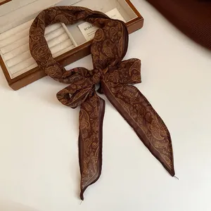 Elegant brown paisley print chiffon scarf tied in a bow, showcased as a fashion accessory