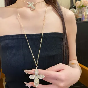 Detail shot of layered gold necklace with sparkling pave flower pendants on model.