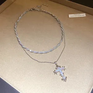 Detailed close-up of retro silver double-layer necklace with sparkling zircon cross pendant.