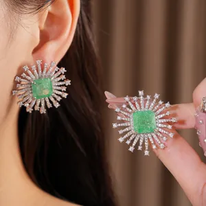 Dettaglio di orecchini vintage a forma di fuochi d'artificio con zircone verde quadrato