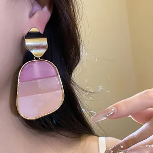 Pendientes retro cuadrados con piedra en degradado rosa y pernos dorados.