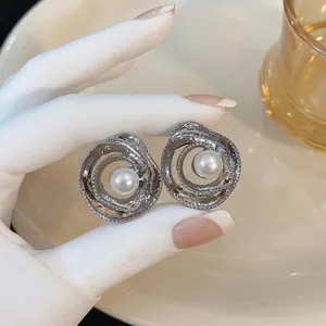 Eleganti orecchini a fiore cavo in argento con una perla centrale per le donne