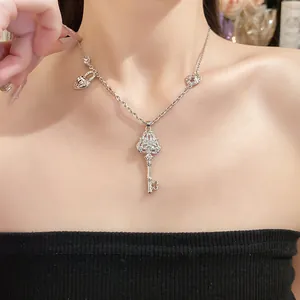 Elegant vintage silver-tone key pendant necklace with zirconia accents on model
