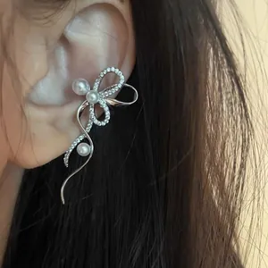 Κοντινό πλάνο από κομψό σκουλαρίκι ear cuff με ζιργκόν και πέρλες σε κορεατικό στυλ