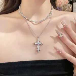 Detailed view of layered silver necklace with sparkling zircon gothic cross pendant