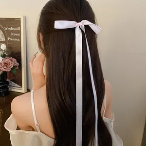 Detailed back view of a soft pink satin ribbon bow hair clip with long elegant streamers