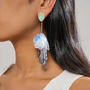 Detailed view of elegant blue resin flower tassel earrings with pearlescent drop