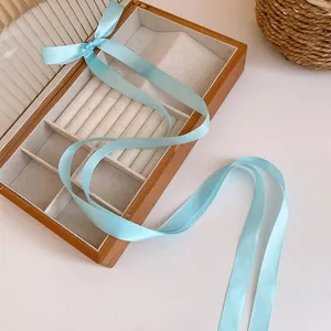 Detail of elegant light blue satin ribbon bow hair accessory for balletcore fashion styles