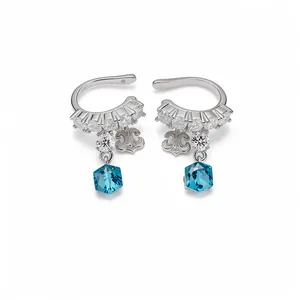 Elegant silver zircon ear cuffs featuring fleur-de-lis charms and blue hexagonal crystals