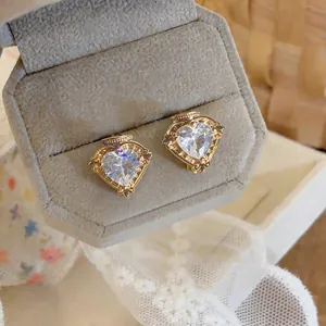 Nahaufnahme eleganter Herz-Zirkon-Ohrringe mit goldenen Filigrandetails