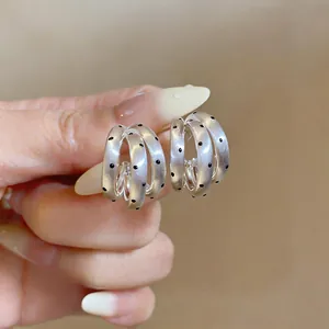 Detail view of French vintage silver multi-layer hoop earrings with black polka dots.
