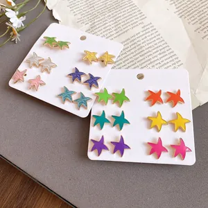 Primer plano de 12 pares de pendientes de estrella de colores en expositores