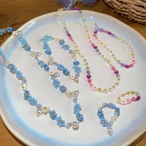 Parure de bijoux faits main fleurs en perles colorées avec perles, colliers et bagues d'été.