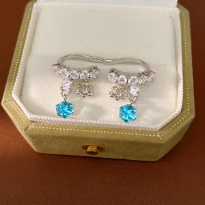 Silver ear clips with sparkling zircon iris motif and blue crystal drops in a green box