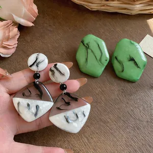 Détail des boucles d'oreilles en résine design avec motif marbré de style encre