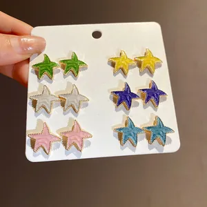 Seis pares de pendientes de estrella esmaltados en colores con elegantes bordes dorados