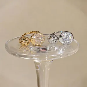 Gold and silver eight-pointed star zircon rings with moon design on glass pedestal