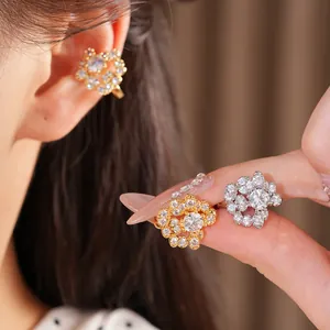 Dettaglio ravvicinato di eleganti ear cuff rotondi in zircone placcati oro 18 carati