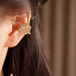 Dettaglio di un elegante polsino auricolare circolare in zircone placcato oro 18K su un modello