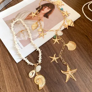 Close-up detail of the gold starfish and shell charms on a summer vacation style necklace