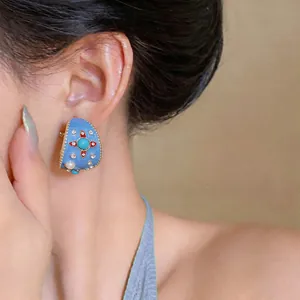 Nahaufnahme eines Vintage-Ohrclips aus blauem Emaille mit Türkis und Perlen