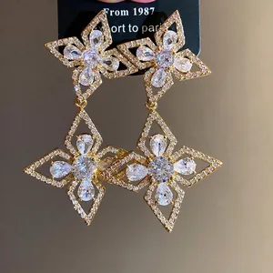 Elegant gold-tone drop earrings featuring zircon-encrusted flower and star patterns.