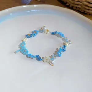 Gros plan d'un bracelet de fleurs en perles bleues fait main avec des perles pour l'été.