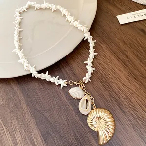Detailed view of starfish beads and golden nautilus shell pendant on beach style necklace