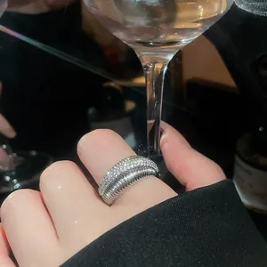 Macro view of a sparkling zircon silver open ring on a finger with a luxury aesthetic
