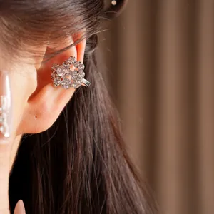 Elegante polsino per orecchio a fiore con zirconia cubica su modella per look di lusso