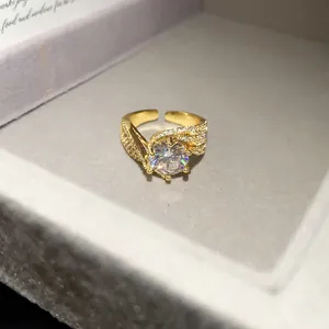 Close-up of 14k gold plated ring with a large round zircon and pavé setting details.