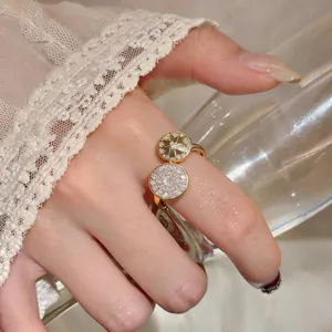Detail view of a gold-finish ring featuring an eight-pointed star and zircon pavé