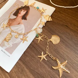 Close-up detail of golden starfish and seashell charms on a beach style pendant necklace