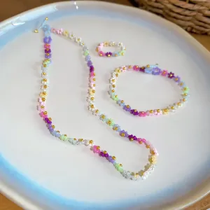 Ensemble de collier, bracelet et bague en perles de fleurs colorées sur une assiette