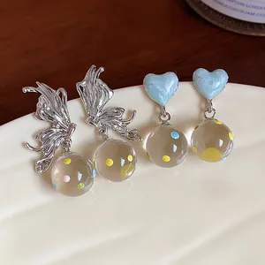 Asymmetric butterfly and heart stud earrings featuring colorful dotted glass beads