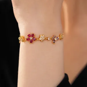 Elegant gold-plated flower bracelet with colorful zircon stones on model's wrist