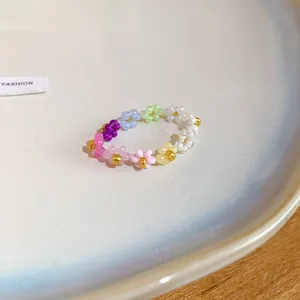Gros plan d'une bague de fleurs en perles colorées avec des centres dorés