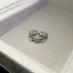Detail view of silver-tone zircon geometric open ring with interlocking link design