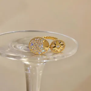 Detail of gold open ring featuring zircon-pave star and moon medallions on glass