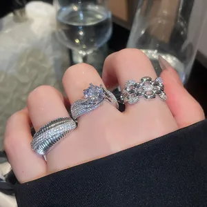 Detailed close-up view of three sparkling cubic zirconia rings on a hand, silver-plated finish