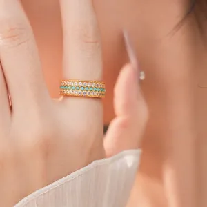 Elegante anello dorato a tre file con turchese e brillanti zirconi sulla modella