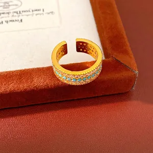 Anello aperto vintage placcato oro con tre file di zirconi e di pietre turchesi.