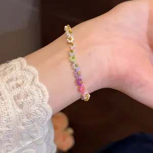 Gros plan d'un bracelet en perles de fleurs colorées porté au poignet