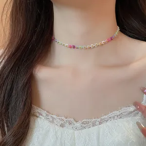 Gros plan détaillé d'un collier ras du cou fleuri et coloré porté par un modèle chic.
