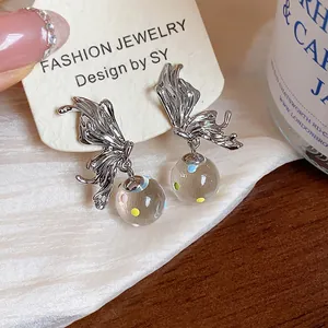 Close-up of silver butterfly earrings with colorful dotted glass balls on display card