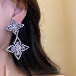 Close-up detail of luxury silver needle zircon double flower drop earrings on model ear
