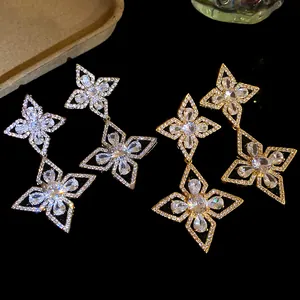 Detail showing sparkling zirconia flower dangle earrings in gold and silver finishes